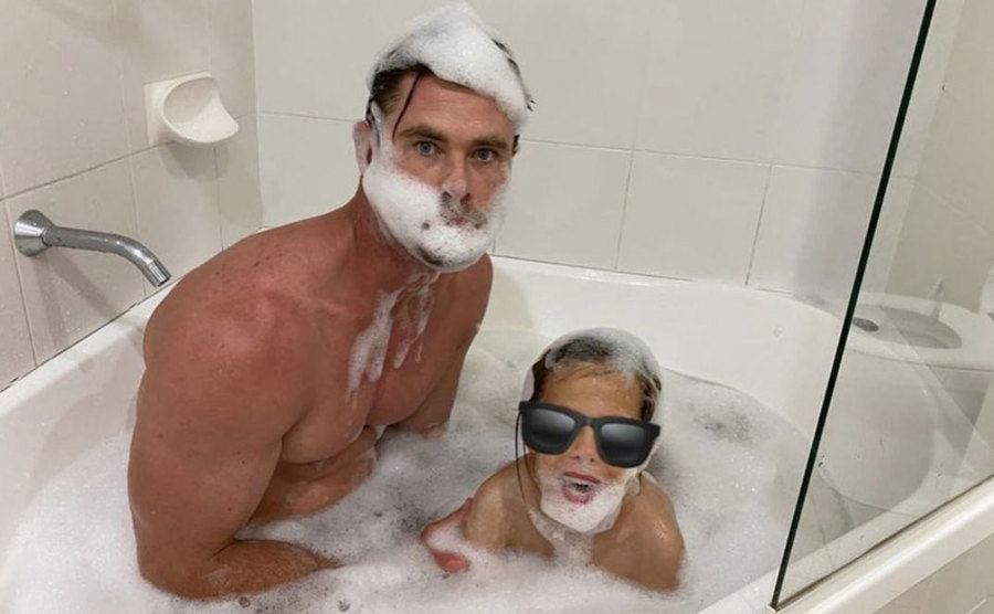 Chris Hemsworth and his son are making bubble beards in the tub. 