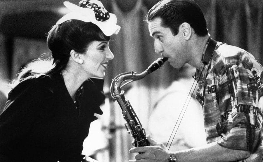 A movie still of De Niro staring at Minnelli’s eyes while playing the saxophone.