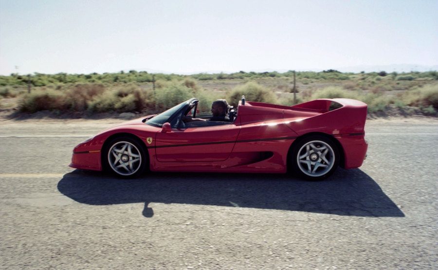A dated picture of Tyson driving his Ferrari on the road.