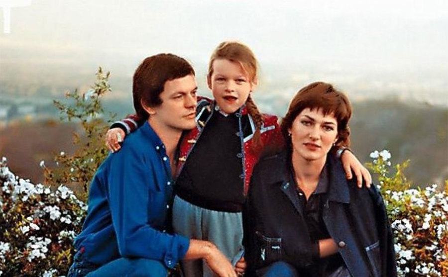 An image of young Milla with her father and mother.