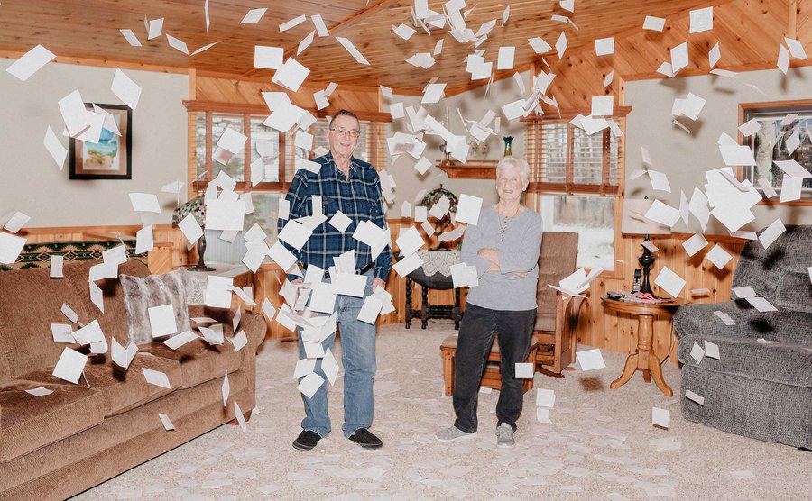 Jerry and Marge pose in their living room surrounded by tickets. 