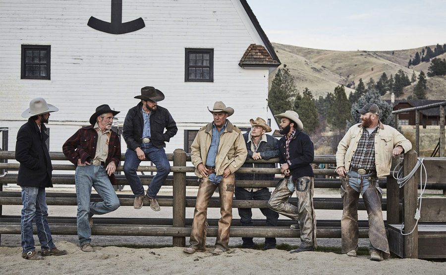 The cast of Yellowstone poses on the ranch. 