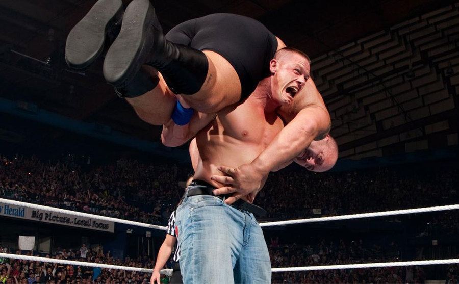 John Cena throws The Big Show over his shoulders. 