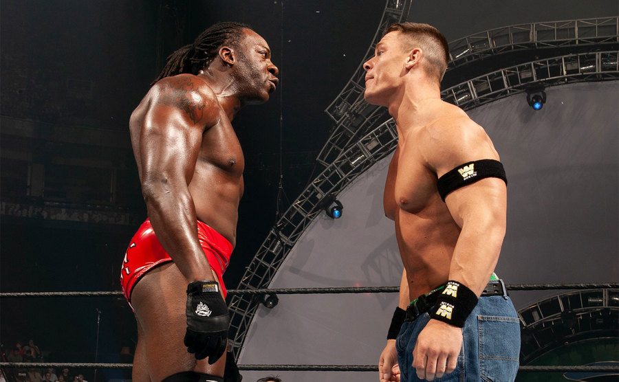 Booker T and John Cena face off in the ring. 