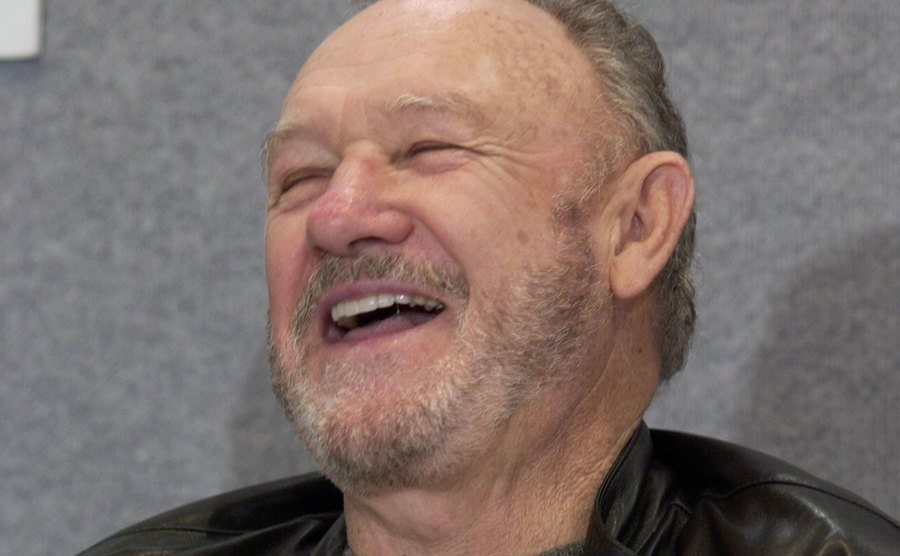 An image of Hackman laughing during a press conference.