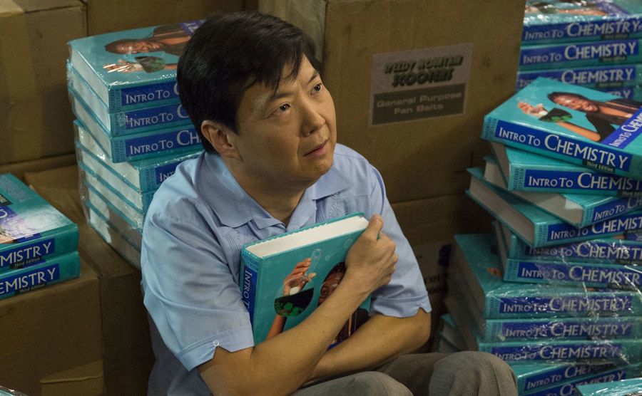 A still of Jeong sitting surrounded by books in a scene from Community.