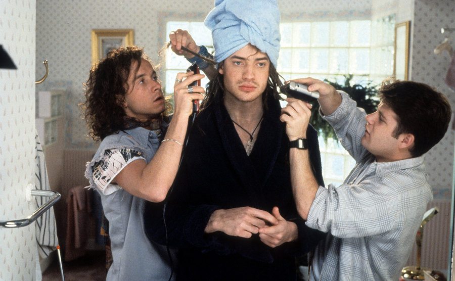 Brendan Fraser is being groomed by Sean Astin and Pauly in a scene from Encino Man.