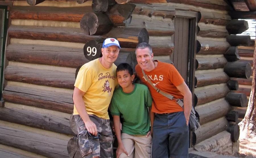 Peter, Kevin, and Danny take a picture in a wooden cabin during the holiday.