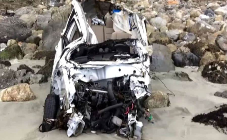 An image of the wrecked car by the shore.