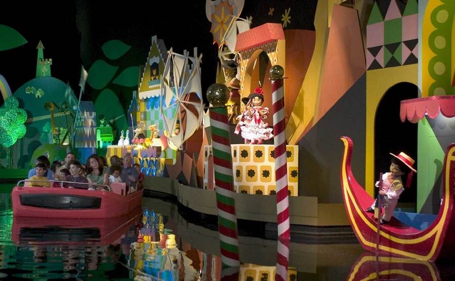 Park goers go on the It’s a Small World ride. 