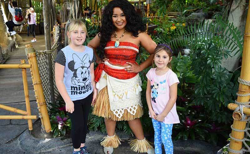 Moana poses with two little girls at the park. 