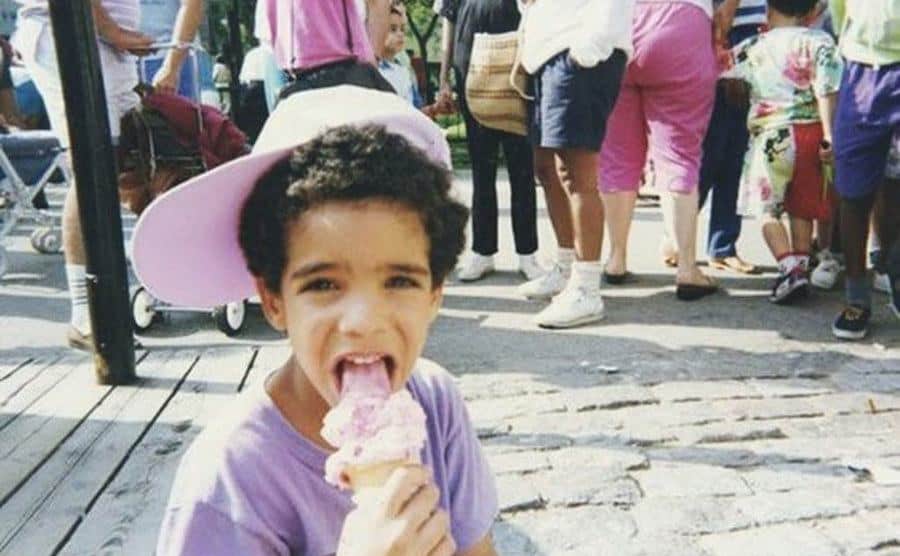 A young Drake is eating an ice cream. 