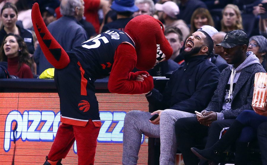 Drake shares a joke with the Toronto Raptors mascot. 