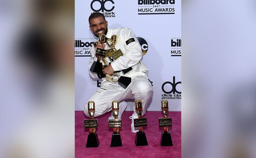 Drake poses with multiple awards. 
